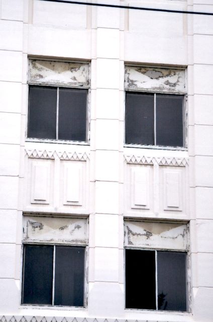 Before: exterior view of non-original replaced windows prior to construction